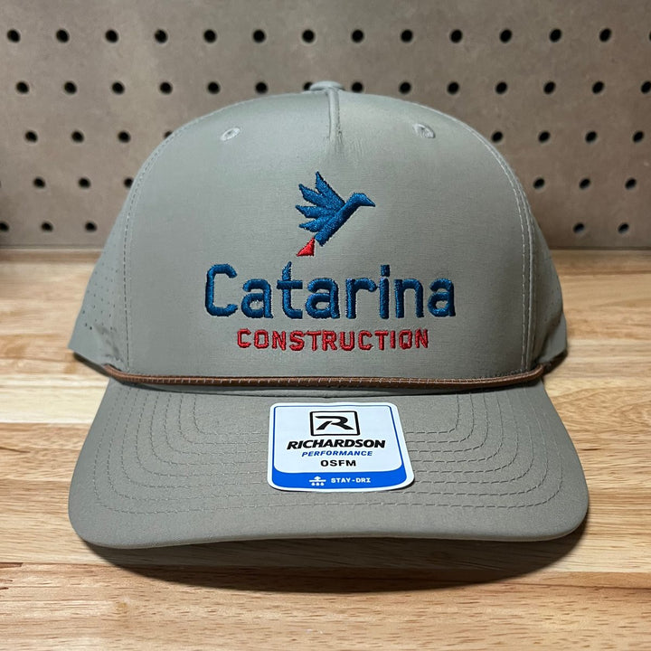 Embroidered construction company logo on a khaki rope hat
