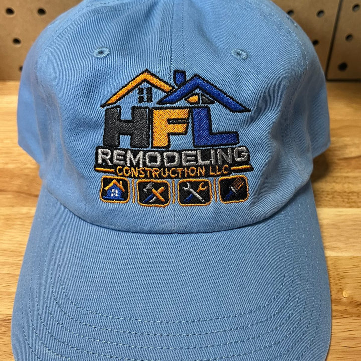 Embroidered remodeling and construction company logo on a light blue unstructured dad hat