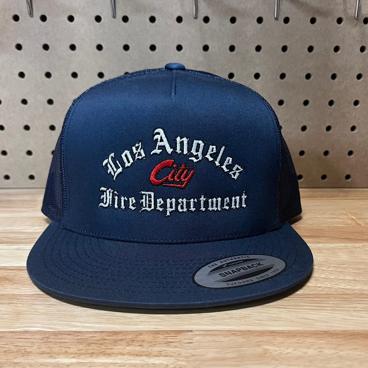 Embroidered fire department logo on a navy flat bill trucker snapback