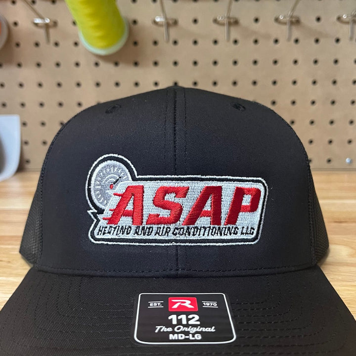 Embroidered heating and air conditioning company logo on a black Richardson 112 trucker hat