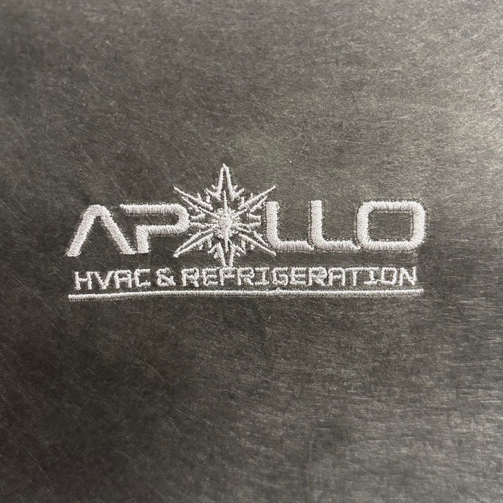 Embroidered HVAC and refrigeration company logo stitched as a flat sew-out on black backing, a real proof before production