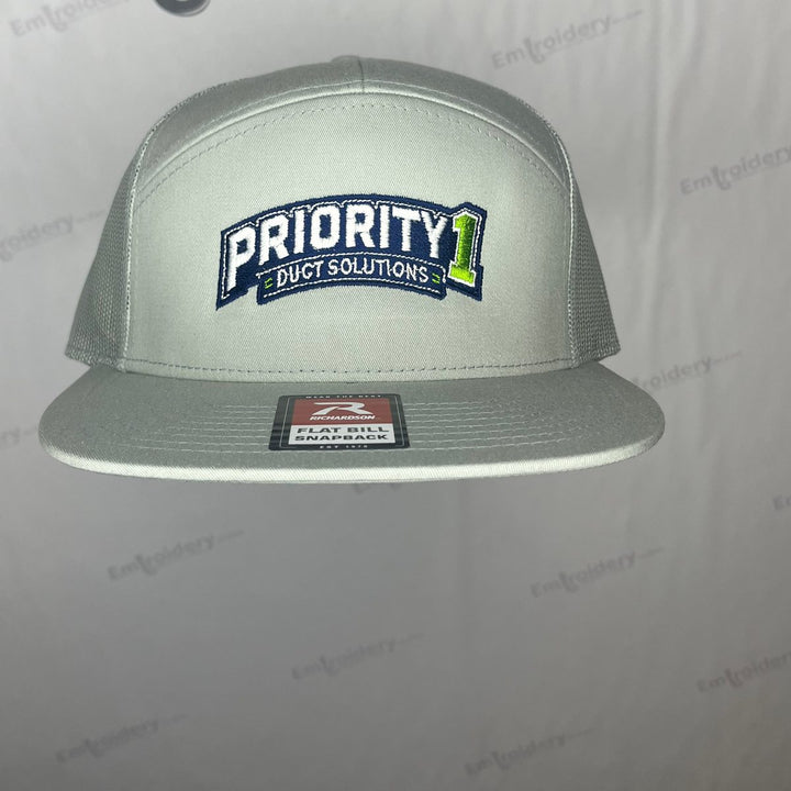 Embroidered duct cleaning company logo on a light grey flat bill seven panel snapback