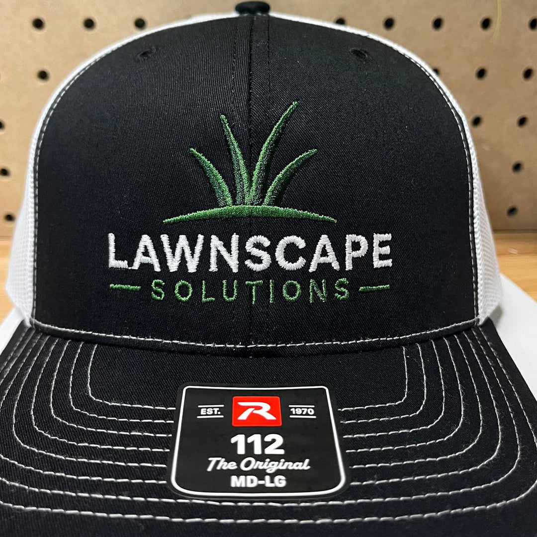 Embroidered lawn and landscape company logo on a black and white Richardson 112 trucker hat