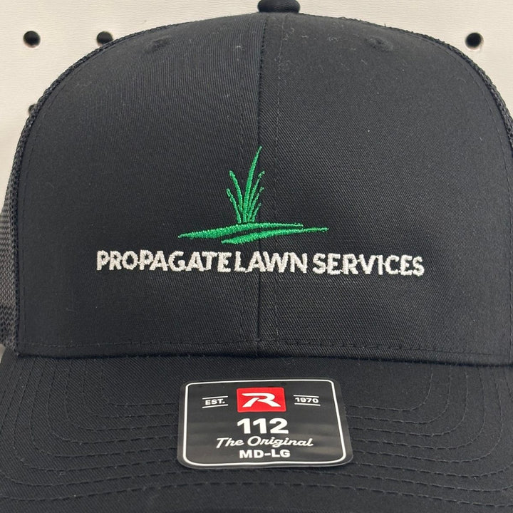 Embroidered lawn services company logo on a black Richardson 112 trucker hat