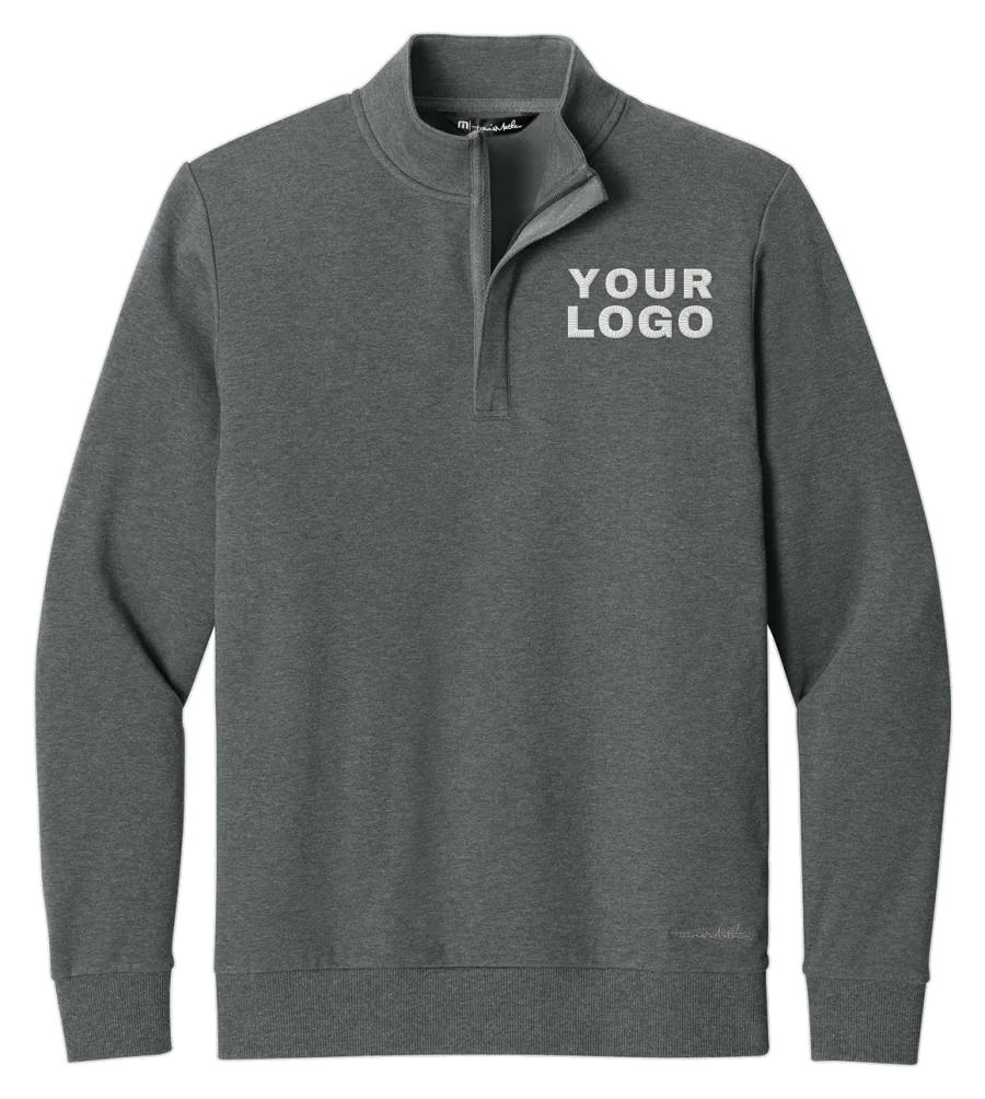 Dark grey TravisMathew quarter-zip pullover with a YOUR LOGO placeholder on the left chest